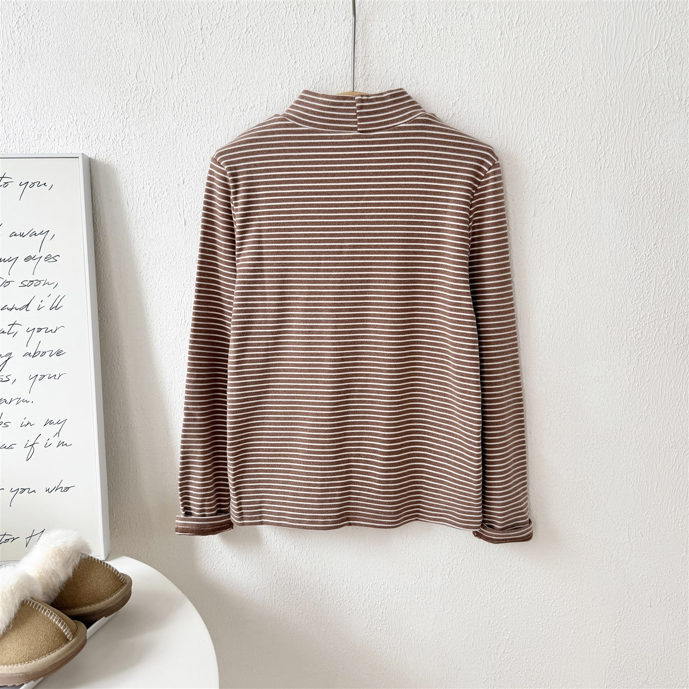 Striped brown children's knit top displayed on hanger